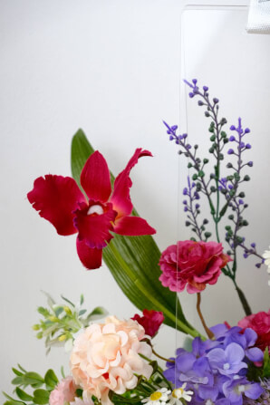 ดอกไม้ประดิษฐ์ผ้าในแจกัน  JGLORYFLOWER  แจกันพลาสติกใส รูปทรงกระเป๋า ดอกไม้คละชนิด สีม่วง/ส้ม_3