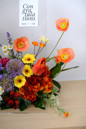ดอกไม้ประดิษฐ์ผ้าในแจกัน  JGLORYFLOWER  แจกันพลาสติกใส รูปทรงกระเป๋า ดอกไม้คละชนิด สีม่วง/ส้ม_5