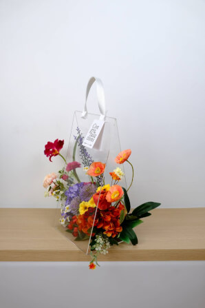 ดอกไม้ประดิษฐ์ผ้าในแจกัน  JGLORYFLOWER  แจกันพลาสติกใส รูปทรงกระเป๋า ดอกไม้คละชนิด สีม่วง/ส้ม_6